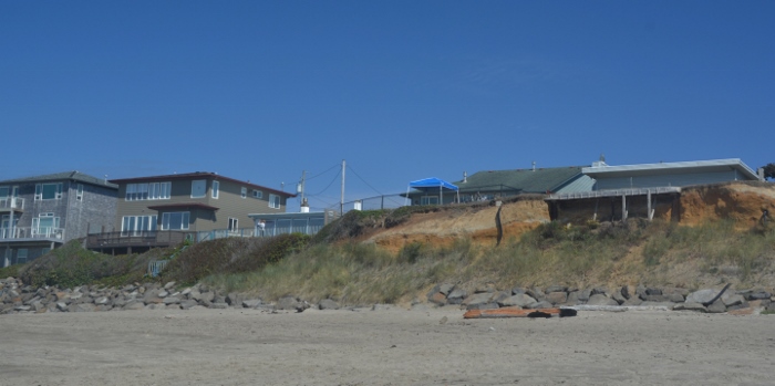 houses overlooking beach dangerously close to eroded cliff